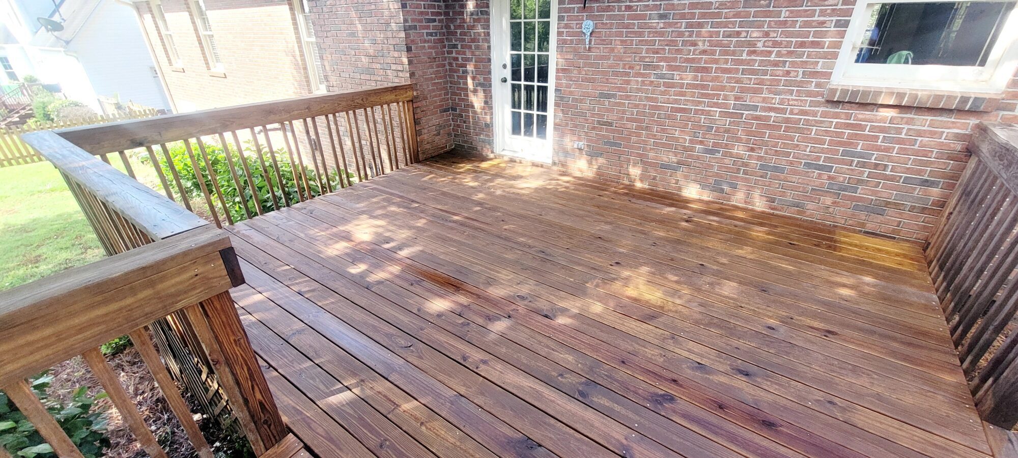 The same deck after washing and staining, now a rich reddish brown